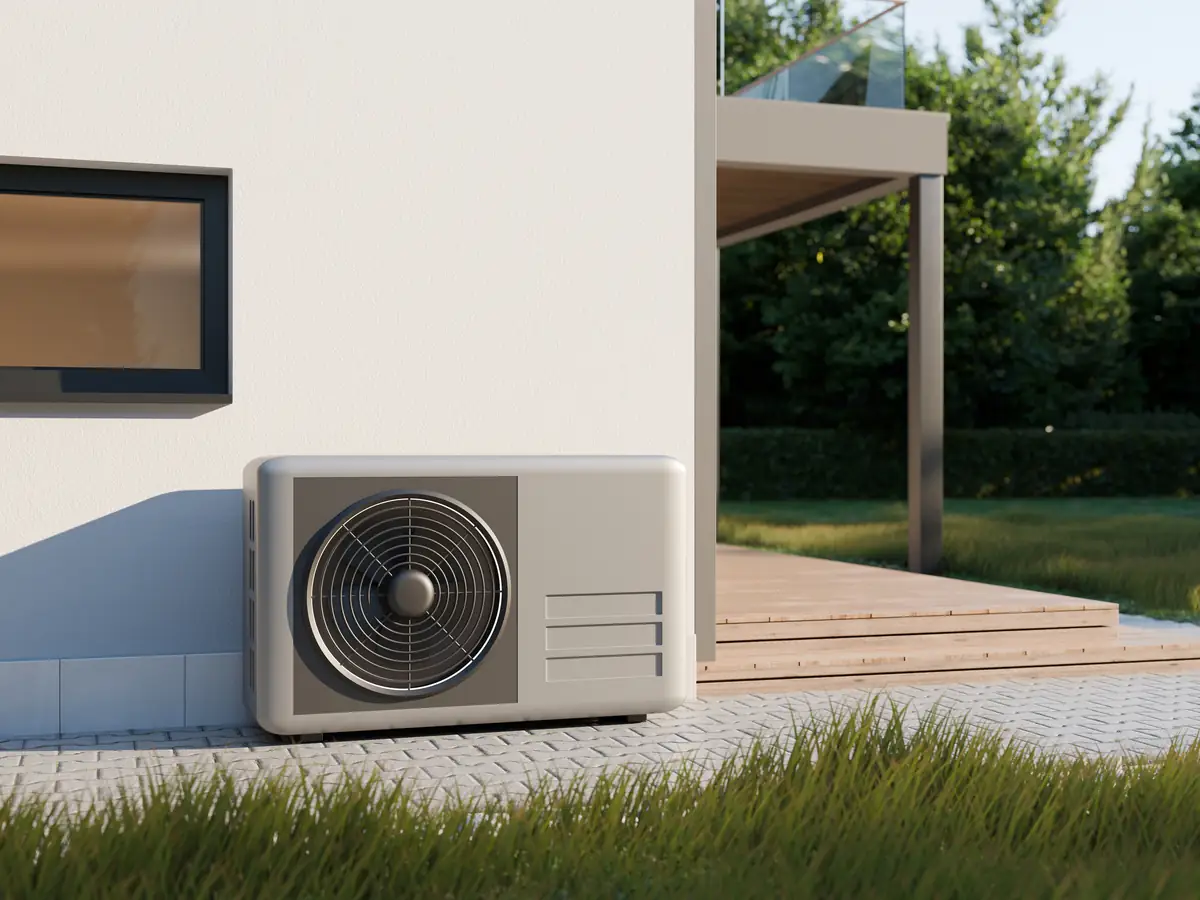 Außeneinheit einer Wärmepumpe neben einem Haus