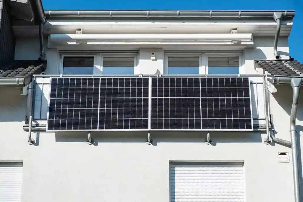 Ein Balkonkraftwerk ist am Balkongeländer befestigt.