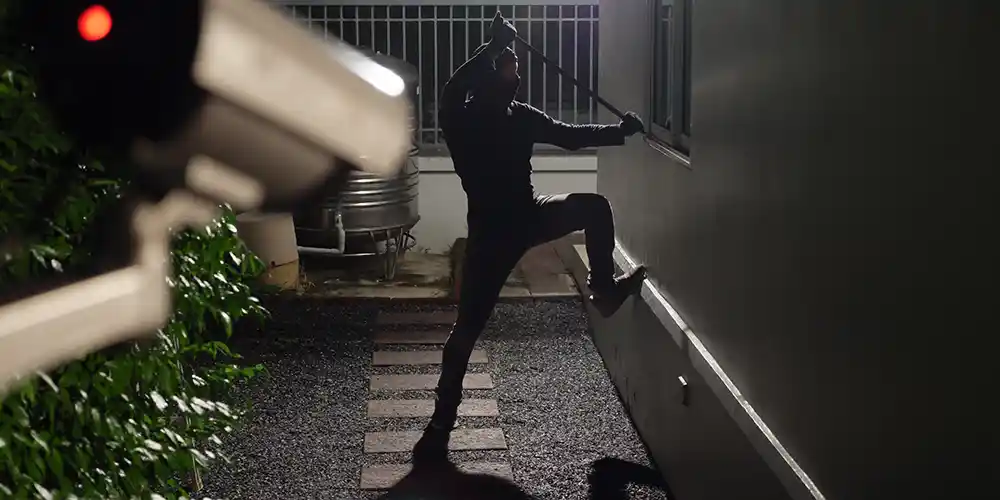 Einbrecher Einbruch in ein Haus, Einbrecher außen am Fenster