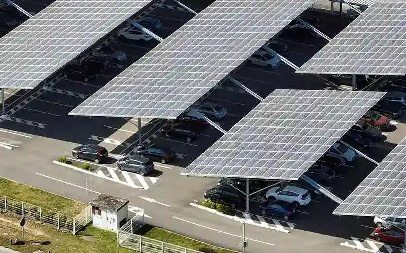 Photovoltaik-Anlage als Parkplatzüberdachung, sehr großer Parkplatz mit vielen Autos ist voll überdacht mit PV.